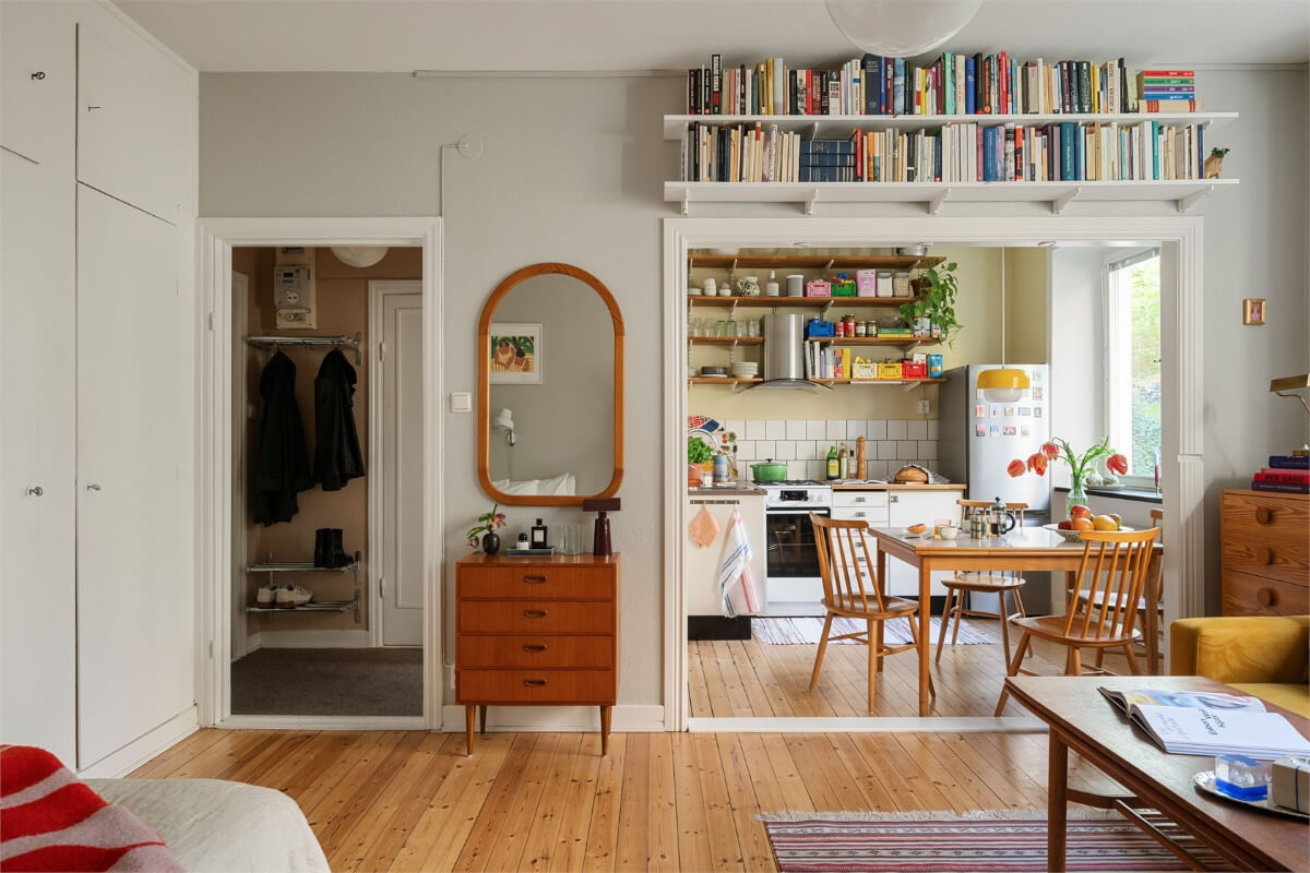 gray studio apartment bookshelves above doorframe built-in wardrobes
