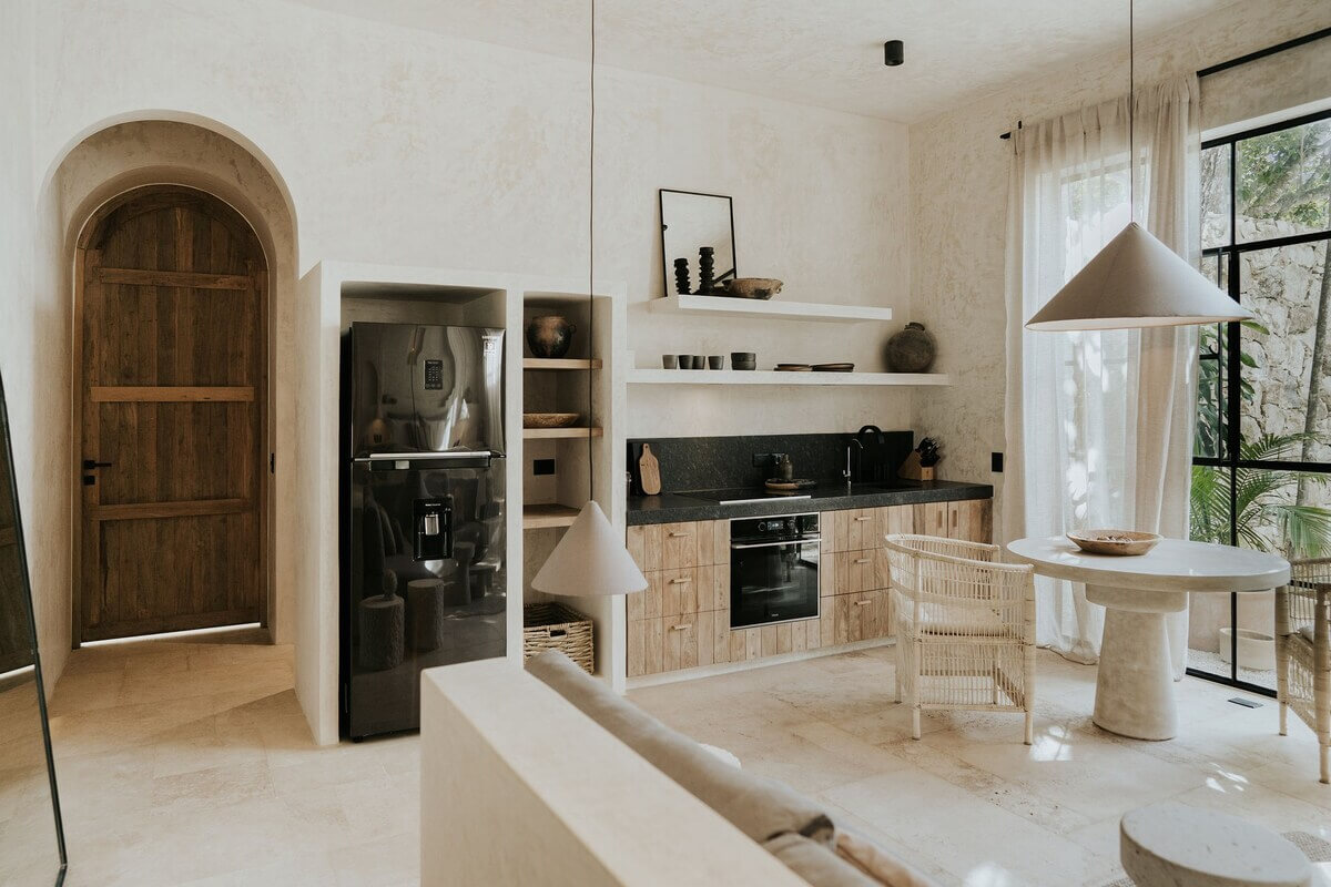 kitchen-living-room-shelves-round-dining-table-arched-wooden-door-nordroom