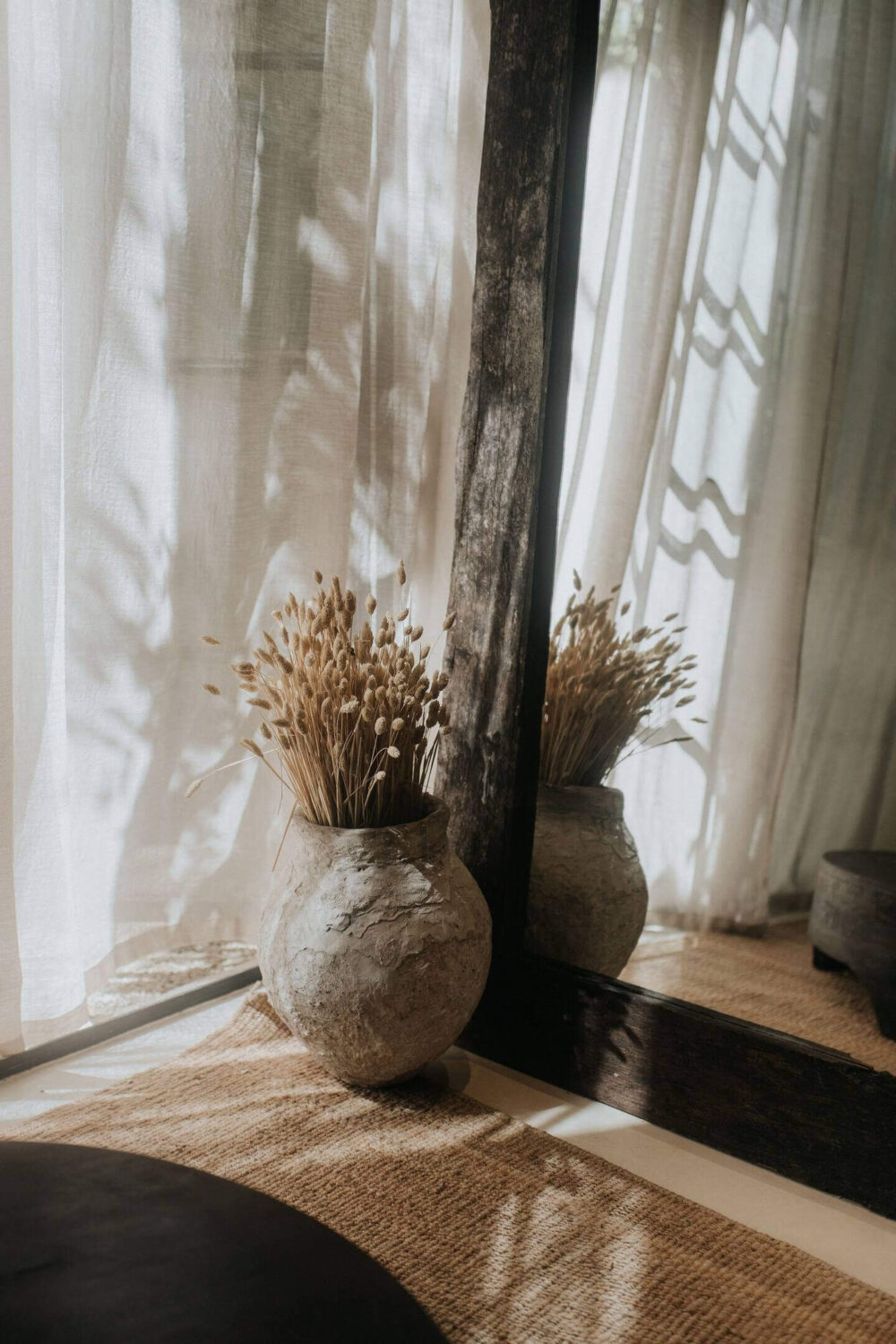 living-room-detail-large-wooden-mirror-stone-vase-nordroom
