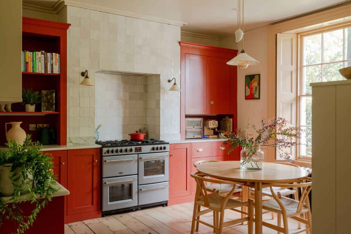 red kitchen with zellige tiles and round dining table
